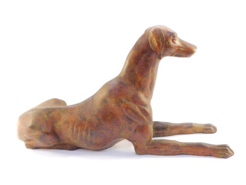 A hollow cast brass figure of a greyhound, with a patinated finish, modelled in recumbent pose, 56cm wide.