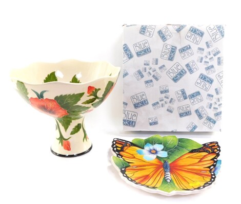 A Blue Sky pottery pedestal bowl decorated in the Hibiscus pattern, against a cream ground, printed marks, 24cm high, together with a dish moulded with a butterfly and flowers, printed marks, 31cm diameter (2).