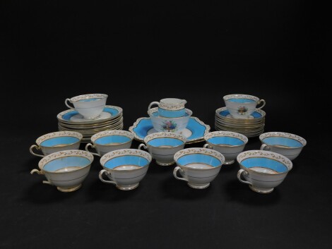 A Foley early 20thC porcelain tea service, decorated with comports of fruit and turquoise bands, printed mark, comprising a pair of bread plates, cream jug, sugar bowl, eleven tea cups, nine saucers, eleven tea plates. (AF)