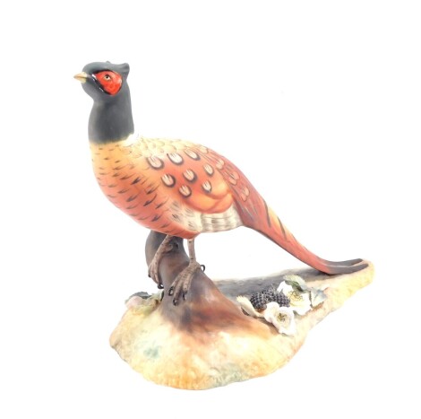 A Royal Crown Derby bisque porcelain figure modelled as a cock pheasant, by Y Harper, printed and painted marks.