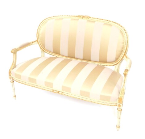 A painted and gilt wood French salon style sofa, with oval backs surmounted by carved ribbons, with over stuffed arms, back and seat, in Regency stripe style material, on turned reeded legs, with acanthus carved mouldings, 93cm high, 120cm wide, 49cm deep