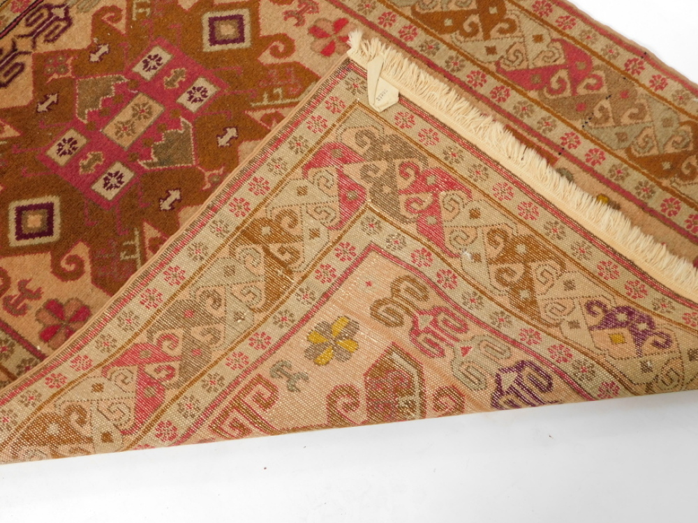 A 20thC Turkish style rug, set with two bold floral central emblems ...