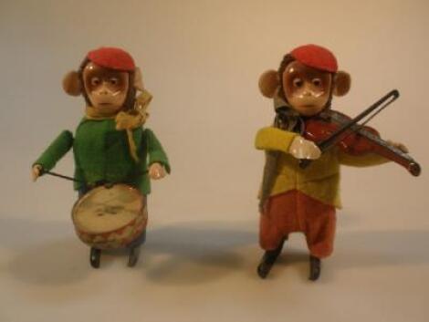 A Schuco clockwork monkey drummer and another