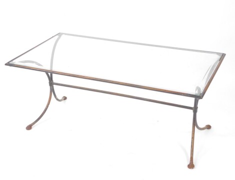 A 20thC glass top coffee table, of rectangular form, with iron frame on shaped legs, joined by a cylindrical horizontal stretcher, 49cm high, 115cm wide, 61cm deep.