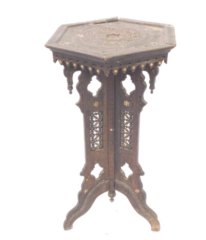 A late 19thC Eastern plant stand, of heavily carved form, the shaped top raised above a pierced stem, set with a lattice work design of scrolls and crosses on shaped feet, 78cm high, 39cm wide. (AF)