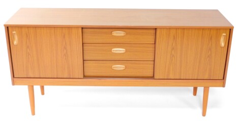 A Schreiber retro teak sideboard, of rectangular form with three cutlery drawers flanked by sliding doors on turned cylindrical legs, 74cm high, 148cm wide, 42cm deep.