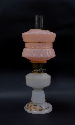 A Victorian milk glass oil lamp base, with brass mount, partially painted with flowers, with later shade and clear glass funnel, 59cm high., (AF)