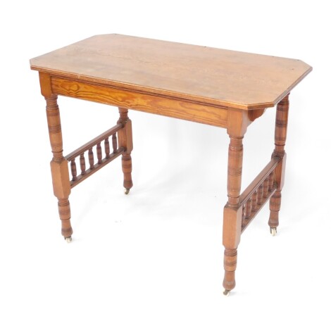 A 19thC pitch pine side table, the canted rectangular top raised on cylindrical legs joined by a double vertical stretcher and terminating in pot castors, 76cm high, 92cm wide, 51cm deep.