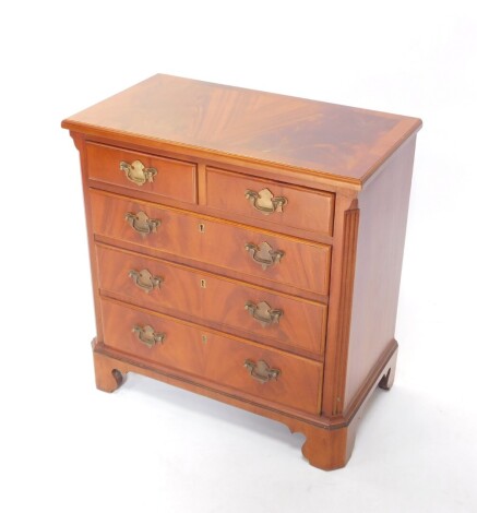 A 20thC chest, the wide crossbanded top raised above two short and three long drawers, each with swan neck plate back handles and flanked by quarter columns, on ogee bracket feet, 68cm high, 66cm wide, 38cm deep.