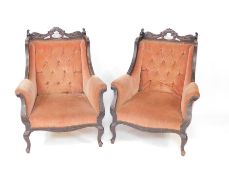 A pair of 19thC walnut stained armchairs, each with carved pierced cresting rails, acanthus leaf sides, studded backs and overstuffed serpentine seats, later peach material, on cabriole front legs terminating on pad feet, 102cm high.