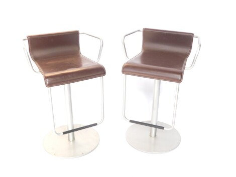 A pair of 20thC metal framed bar seats or stools, each with dark leatherette seats and metal frame work on turned stem and circular feet, 79cm high.