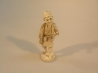 A Japanese ivory sectional okimono figure of a young man signed and decorated