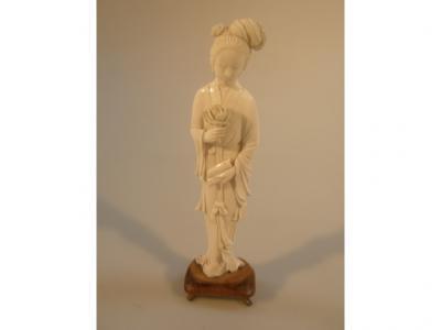 A Chinese ivory figure of a lady of virtue holding scrolls and a flower