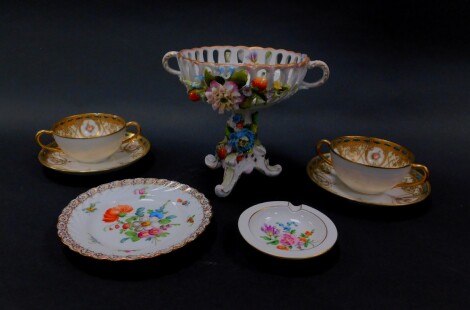 A German porcelain pedestal sweetmeat basket, encrusted with flowers and fruit, Dresden porcelain ashtray painted with flowers, saucers similarly decorated and a pair of Noritake porcelain twin handled soup cups and saucers. (AF)