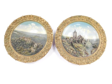 A pair of Wilhelm Schiller late 19thC relief moulded chargers, one showing a View of the Rudelsburg, no 9500., the other showing a View of Schwarzburg Thuringen Schloss vom Helenensitz, no 9592, 40cm diameter. (AF)