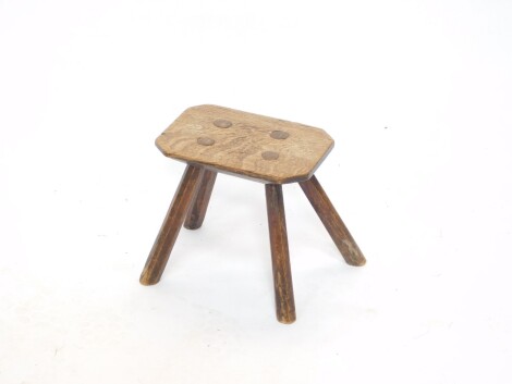 A Victorian oak and elm milking stool, raised on four fluted legs, 25.5cm wide.