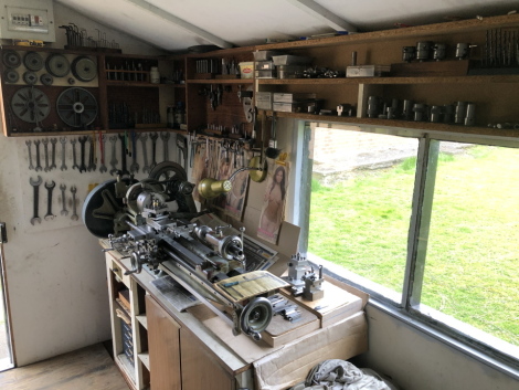 A Myford lathe workstation and accessories, comprising single phase bench top lathe, and tooling as illustrated, to include gearing, face plates, drills, centres, colletts, micrometres, chucks, spanners, etc. (around the walls), and cabinet base with dril