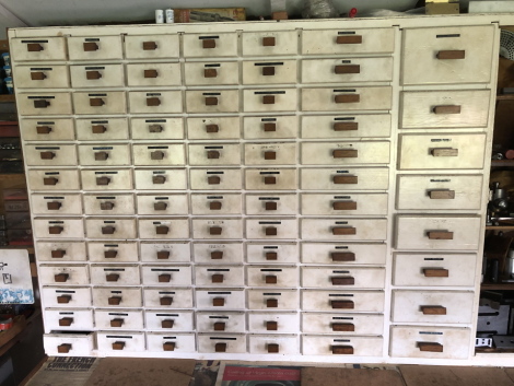 A bank of eighty six white painted drawers, containing engineering objects, ranging from circlips, carbide tips, HRD bushes, ballraces, centres, plug gauges, springs, drills, calipers, centre drills, taps, dies, needle rollers, tool bit blanks, precision 