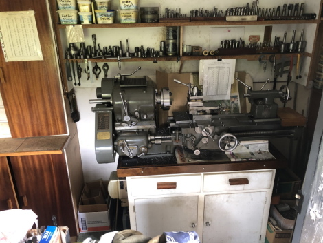 A Denham lathe workstation, comprising single phase bench top lathe, upper shelves with colletts, drills, reamers, studs, split rings, spinning tooling, centres, chucks,etc., and lower cabinet with cutting tools, chuck jaws, further chucks, etc. Viewing: 