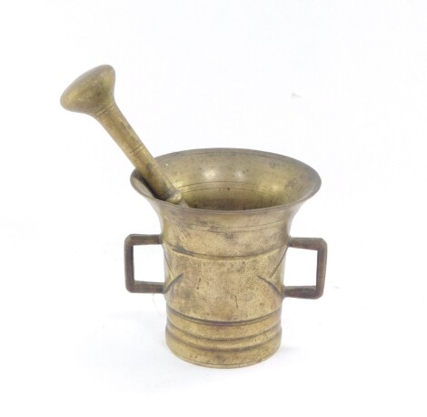 An 18thC brass pestle and mortar, of tapering bell shaped form, with angular C shaped handles, 9cm high.