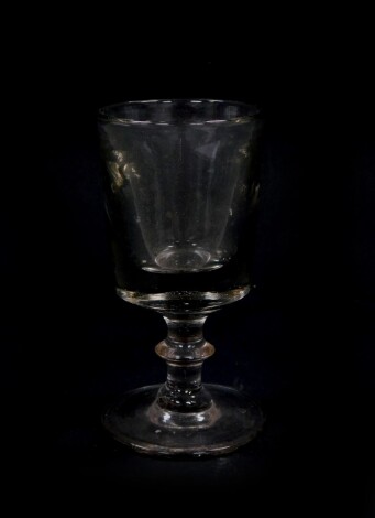 An early 19thC deceptive or toastmaster's rummer, the cylindrical bowl on an inverted stem and circular foot, plain pontil, 14cm high.
