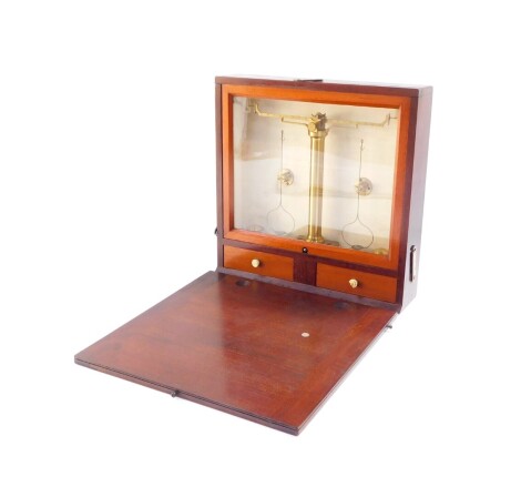 An early 20thC brass travel scales, in mahogany case with hinged front revealing globe section, the scale on cylindrical stem above two drawers, in fitted case with visable dovetails, 8cm high, 25cm wide, 21cm deep.