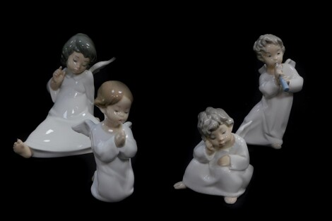 A Lladro porcelain figure of a seated cherub, and three further cherubs, one praying, another in contemplation, the third playing a woodwind instrument.