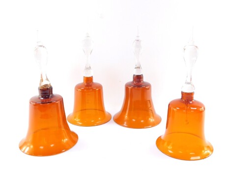 Four Victorian deep amber glass bells, with clear glass handles, 30cm high. (AF)
