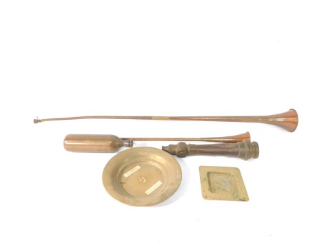 A copper and brass post horn, 131cm wide, another smaller, 75cm wide, a Charles Winn & Company brass fire nozzle, an ICI brass cannister, and two brass dishes. (6)