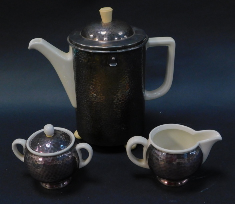 A WMF and Hutschenreuther porcelain and silver plated three piece coffee set, mid century, in the Bauhaus style, comprising a coffee pot with a heat master type plater insulating sleeve and cover, raised on three ball feet, 24.5cm high, togather with a cr