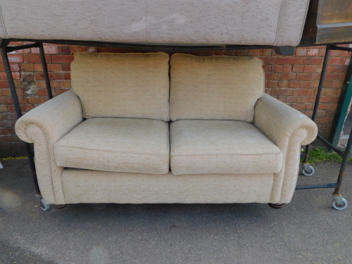 A two seater sofa bed, upholstered in cream patterned chenille fabric, 170cm long.