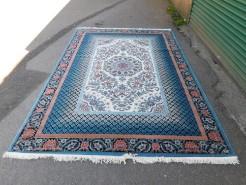 A Bahariye wool rug, blue and cream ground with floral borders and a central medallion, 313cm x 201cm.