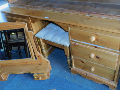 A pine dressing table, with six drawers, 72cm high, 153cm wide, 43cm deep, swing frame mirror and a stool. (3)