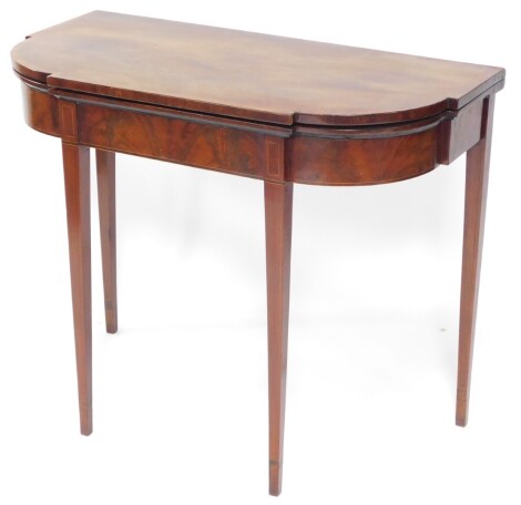 An early 19thC mahogany tea table, the shaped top cross banded in rosewood and raised on square tapering legs terminating in shaped feet, when closed 74cm high, 89cm wide, 44cm deep.