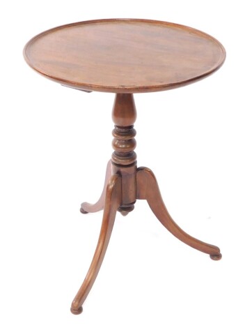 A George III style mahogany wine table, the circular shallow dish top on a baluster stand terminating in triple sabre legs, terminating in compressed orb feet, 65cm high, 51cm diameter.