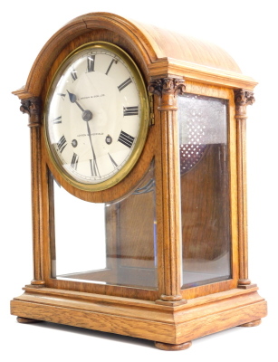 A late 19th/ early 20thC oak mantel clock, the dial stamped H.L. Brown and Sons Ltd London and Sheffield, the arched case with two fluted pillars, on bun feet, 37cm high.