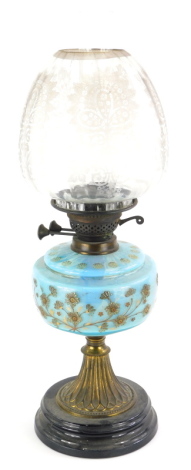 A Victorian oil lamp, with a floral etched shade, a blue glass reservoir decorated with flowers, on a gilt brass support and ceramic base, 59cm high.