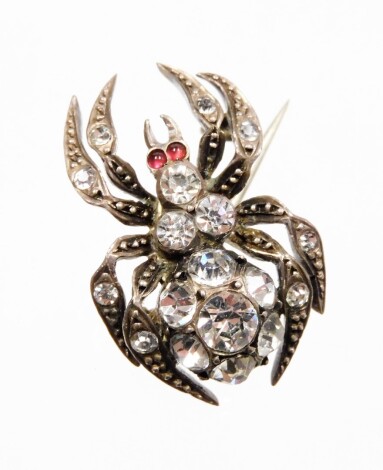 A late Victorian spider brooch, the body set with various paste stones, in a white metal setting, stamped 900, on single pin back, 2.5cm high.