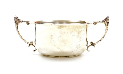A George V silver trophy cup, the plain circular bowl with angular leafy handles surmounted by acorns on a circular foot, Birmingham 1931, 7cm high, 3.3oz all in.