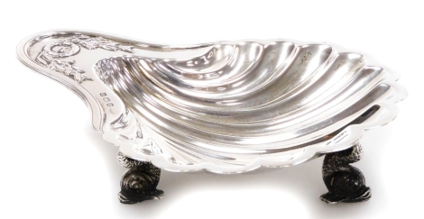 A George V shell shaped butter dish, of shaped form with raised garland handle on triple dolphin feet, Birmingham 1913, 15cm, 3.2oz.