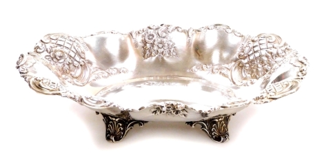 A Victorian silver dish, by Thomas Latham and Earnest Morton, with a scroll border and repousse and pierced lattice decoration, on quadruple scroll feet, Birmingham 1897, 12oz.