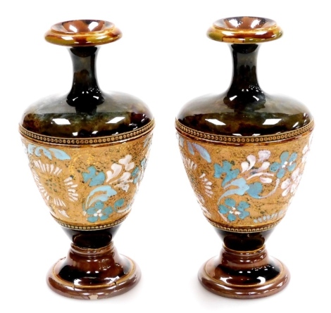 A pair of Royal Doulton Lambeth Stoneware vases, with a brown and green mottled glaze and floral central body, numbered 799, (one AF) 18cm high.