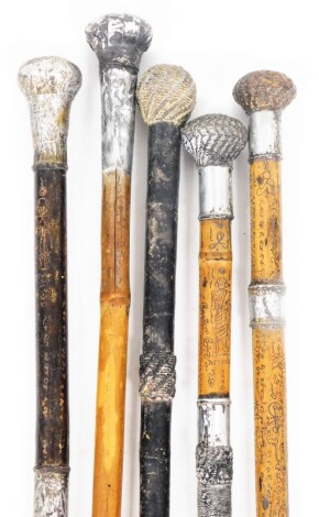 A group of Eastern style walking canes, each with silver plated tap ends, of varying sizes. (5)