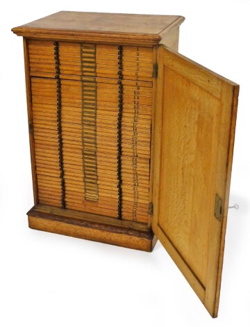 A 19thC oak microscope slide cabinet, the plain door revealing forty drawers, with vacant metal card mounts and knob handles, on a block base, 94cm high, 62cm wide, 46cm deep.