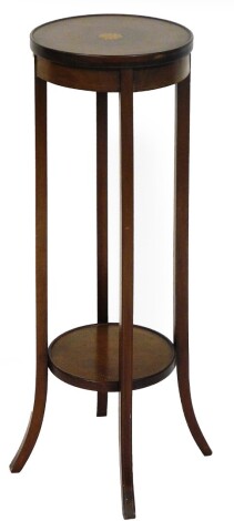 An Edwardian mahogany and boxwood strung plant stand, the circular top centred by a sun patera, on square sabre legs joined by a circular under tier, 92cm high, 31cm diameter.