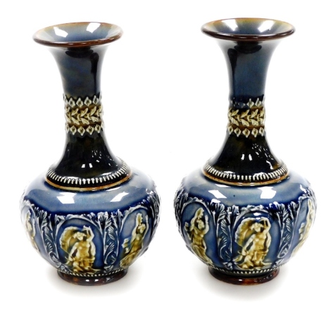 A pair of Doulton Lambeth stoneware vases, each with blue, brown and green mottled decoration depicting neoclassical figures and flowers, with Doulton Lambeth stamp to underside, 21cm high.