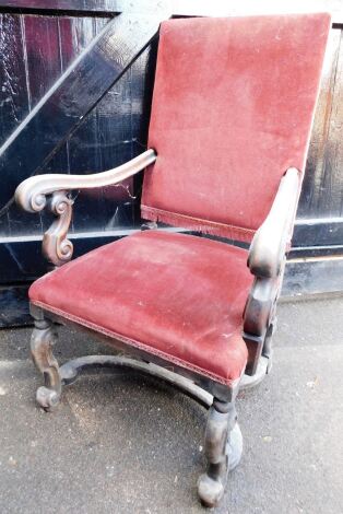 A Continental walnut carver chair, with scrolling arms having s scroll supports, shaped base and velvet upholstery, 66cm wide over arms.