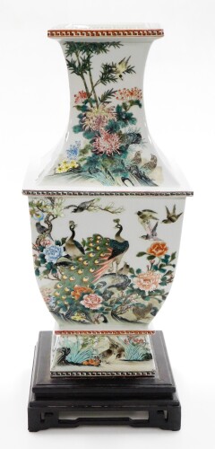 A large Chinese porcelain vase, the square border with red and blue painted design, on a turquoise design, with applied decoration of birds, flowers and leaves, on a stepped base, with blue Chinese character mark to underside, on a ebonised base with blue