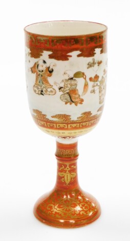 A late 19thC Japanese Kutani goblet, decorated with seated and dancing figures, in Kutani patterning on a cylindrical stem and trumpet base, bears three signatures to underside, 19cm high.