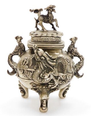 A Chinese polished metal censer, with dragons in high relief and phoenix handles, on three feet formed as waves, the cover with klylin knop, four character Qianlong mark beneath, probably 20thC, 25cm high.